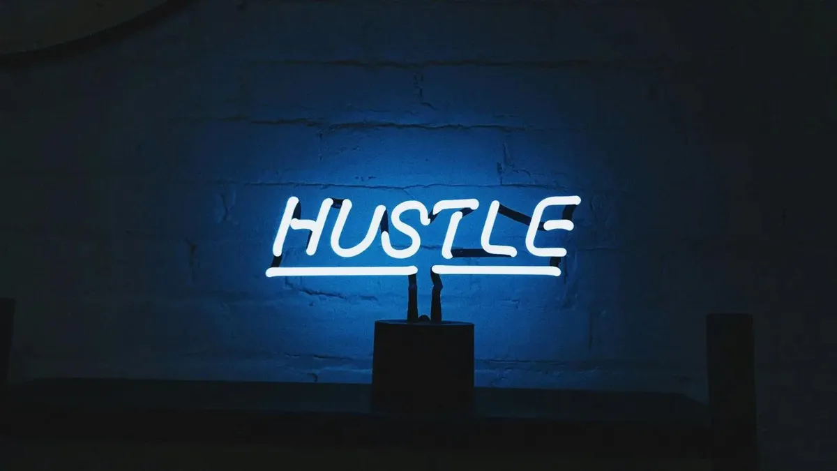 Neon sign that says Hustle