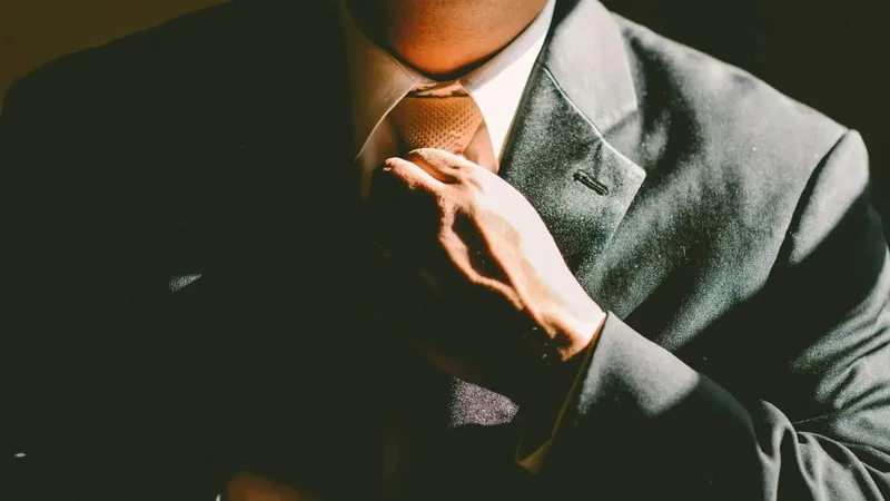 Close-up of man adjusting his tie