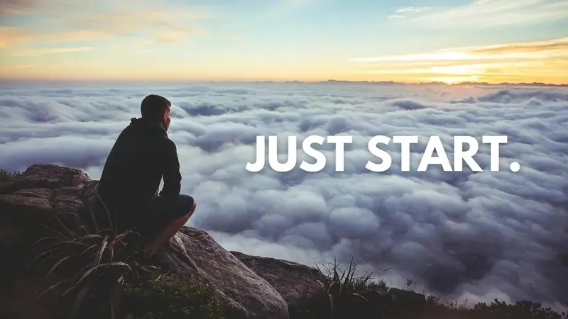 Man looking out at clouds over a cliff. Words that say Just Start