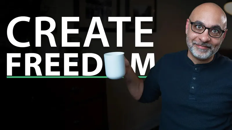 Smiling man, lifting a mug next to the works Create Freedom